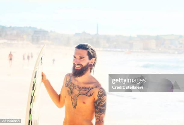 surfer houden zijn surfplank op het strand, bondi beach - lypseaus2015 stockfoto's en -beelden