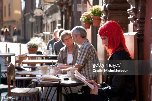 People sit outside the Chokladcoppen cafe on Stortorget Square in the historical city center October 26, 2006 in Stockholm, Sweden.