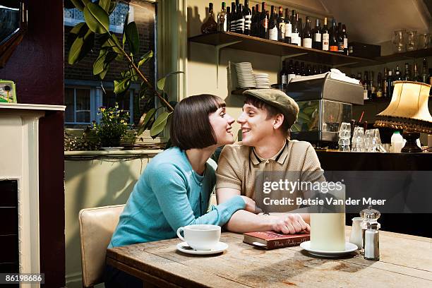 couple touching noses, sitting in cafe. - couple bar stock pictures, royalty-free photos & images