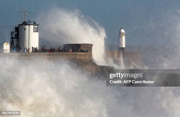 Huge waves strike the harbour wall and lighthouse at Porthcawl, South Wales, on October 16, 2017 as Storm Ophelia hits the UK and Ireland. Ireland...
