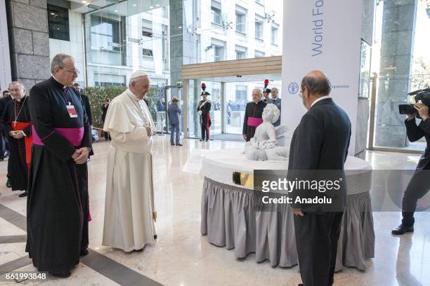 General director José Graziano da Silva and Pope of the Catholic Church, Pope Francis stand in front of a marble statue, depicting the "Aylan Kurdi"...