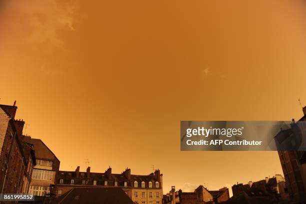Picture taken on October 16 in central Rennes, western France, shows rooftops and the sky after it turned a yellow-ochre colour due to sand from the...