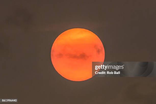 The sun goes a golden yellow colour due to dust from the Sahara being blown in with Storm Ophelia on October 16, 2017 in Fulham, London, UK.