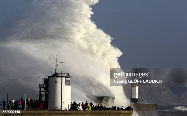 Huge waves strike the harbour wall and lighthouse at Porthcawl, south Wales, on October 16, 2017 as Storm Ophelia hits the UK and Ireland. - Ireland...