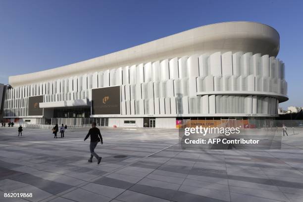 Poeple walk near the U Arena in Nanterre, west of Paris, during its official inauguration on October 16, 2017. The U Arena is the new largest covered...