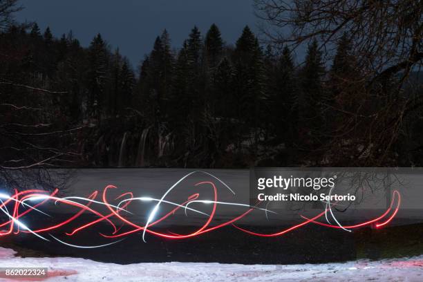 color shapes suspended over night scene with snow - nationalpark plitvicer seen stock-fotos und bilder