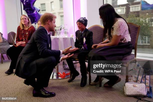 Patron of WellChild Prince Harry meets Marni Ahmed, aged 9, the winner of the Inspirational Child Award aged 7-10, with his mother Gulzeab during a...