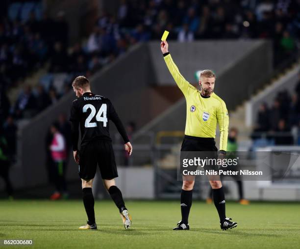 Lasse Nielsen of Malmo FF is shown a yellow card by Glenn Nyberg, referee during the Allsvenskan match between IFK Norrkoping and Malmo FF at...