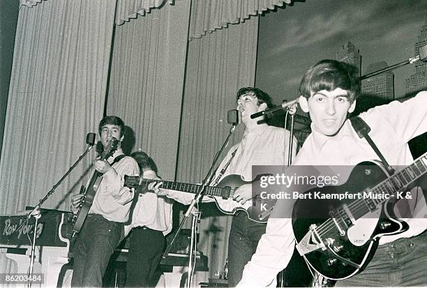 Photo of singer-guitarist John Lennon, singer-bassist Paul McCartney and guitarist George Harrison of The Beatles, live onstage circa May 1962 at the...