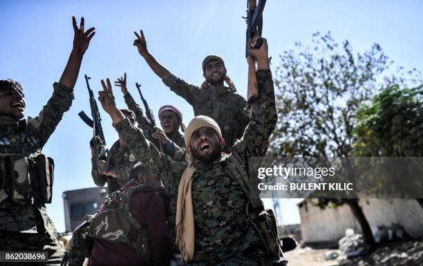 Members of the Syrian Democratic Forces , backed by US special forces, celebrate at the frontline in the Islamic State group jihadists crumbling...