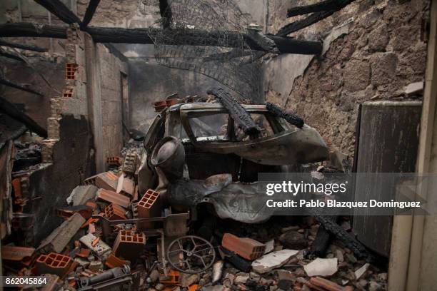Burnt car remains inside a house in the village of Vila Nova, near Vouzela on October 16, 2017 in Viseu region, Portugal. At least 30 people have...