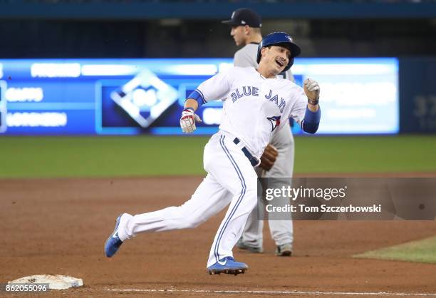 Darwin Barney of the Toronto Blue Jays rounds third base and runs home to score a run on an RBI double by Ryan Goins in the sixth inning during MLB...