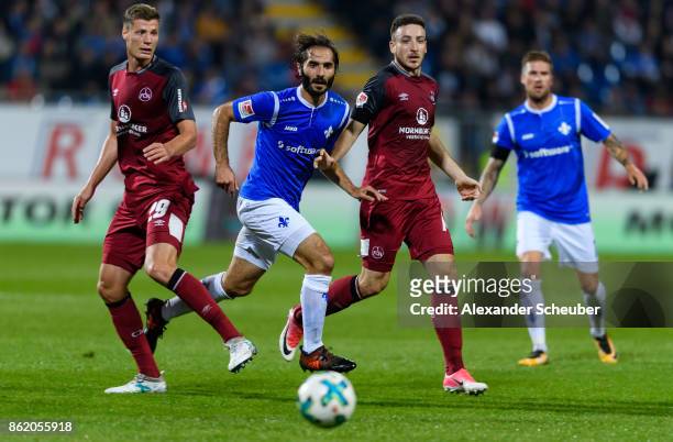 Hamit Altintop of Darmstadt in action against Patrick Erras of Nuernberg and Kevin Moehwald of Nuernberg during the Second Bundesliga match between...
