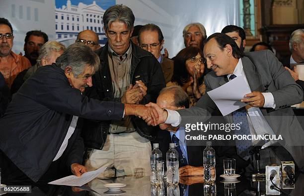 Congress acting President Jose Mujica shakes hands with lawyer Oscar Lopez Goldaracena, member of the Commission to abolish the amnesty law after...