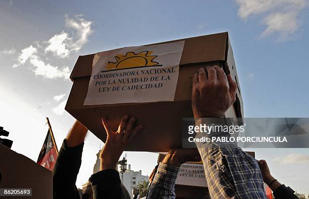 People head for the Congress in Montevideo carrying boxes containing the required signatures to call a referendum to abolish an amnesty law, on April...