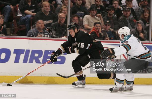 Travis Moen of the San Jose Sharks reaches around for the puck against Ryan Getzlaf of the Anaheim Ducks during Game Four of the Western Conference...
