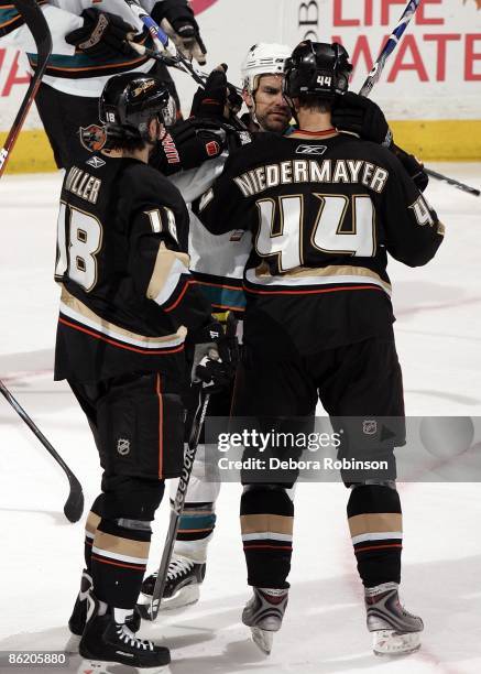 Rob Niedermayer and Andrew Ebbett of the Anaheim Ducks scrum with Dan Boyle of the San Jose Sharks during Game Four of the Western Conference...