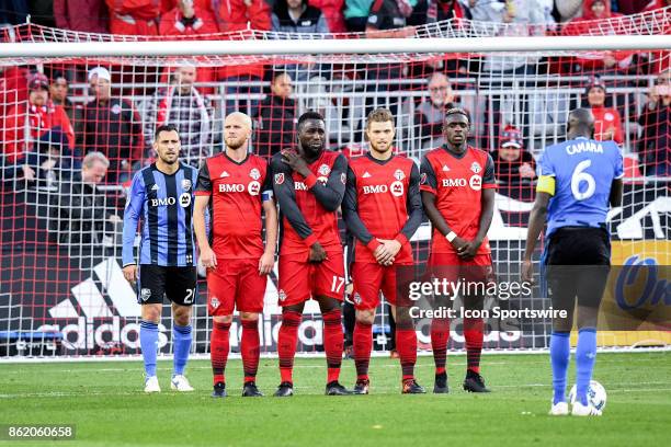 Matteo Mancosu of Montreal Impact and Michael Bradley , Jozy Altidore , Eriq Zavaleta , Justin Morrow of Toronto FC make up the wall for a Hassoun...