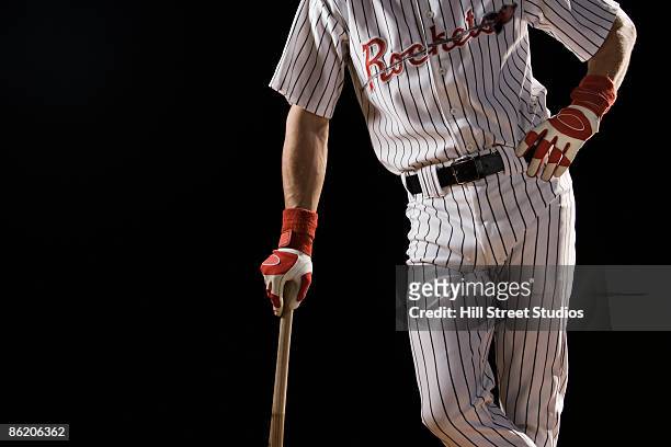midsection portrait of baseball player leaning on bat - divisa da baseball foto e immagini stock