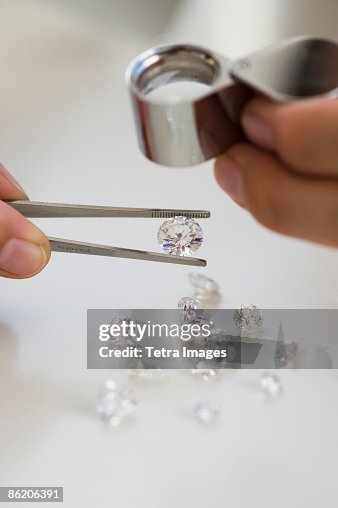Gemologist inspecting diamonds using loupe Gemologist inspecting diamonds using loupe