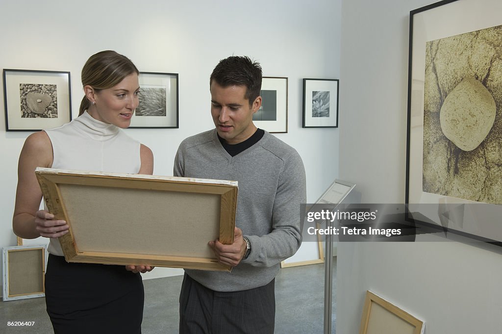 Curators examining painting in art gallery