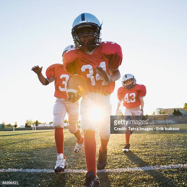 football players running on field - rush american football stockfoto's en -beelden