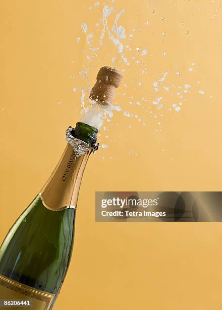 cork exploding from champagne bottle - sektkorken stock-fotos und bilder