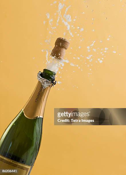 cork exploding from champagne bottle - bottle photos et images de collection