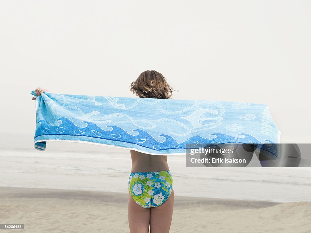 Girl holding towel on beach