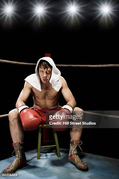 boxer sitting on stool in corner of boxing ring - championship ring stock-fotos und bilder