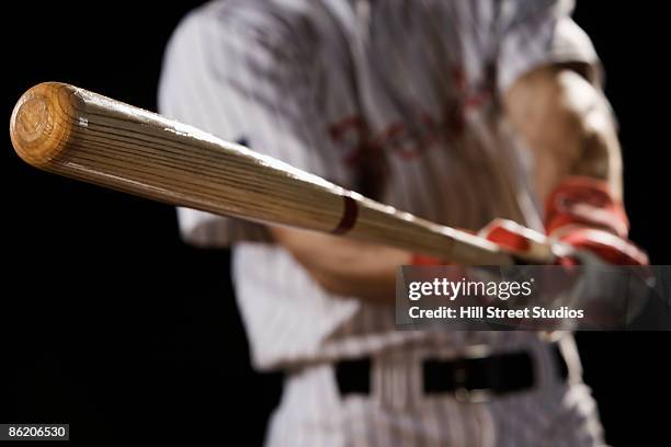 close up of baseball player swinging bat - bate de béisbol fotografías e imágenes de stock