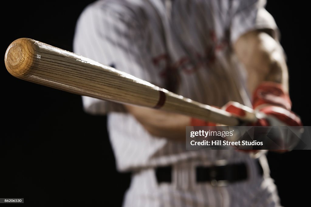 Close up of baseball player swinging bat