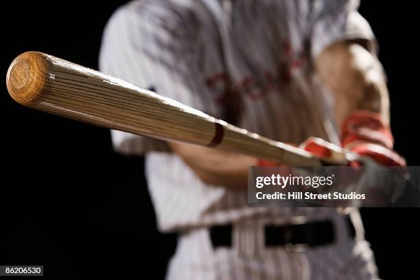 close up of baseball player swinging bat - baseball bat swing stock pictures, royalty-free photos & images