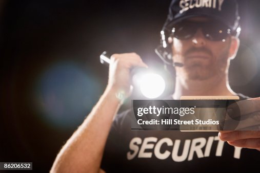 Bouncer checking identification with flashlight Bouncer checking identification with flashlight