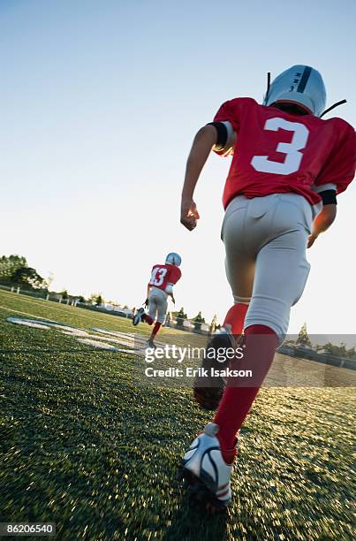 football players running on field - american football field low angle stock pictures, royalty-free photos & images