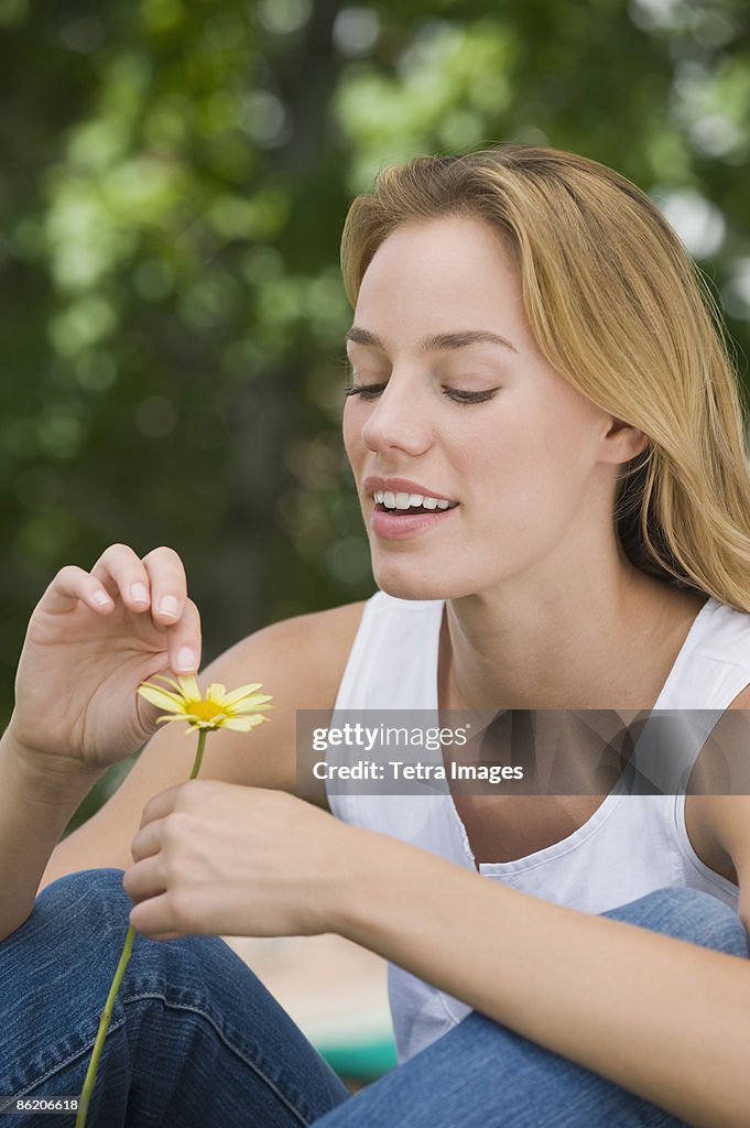 Woman picking petals off flower