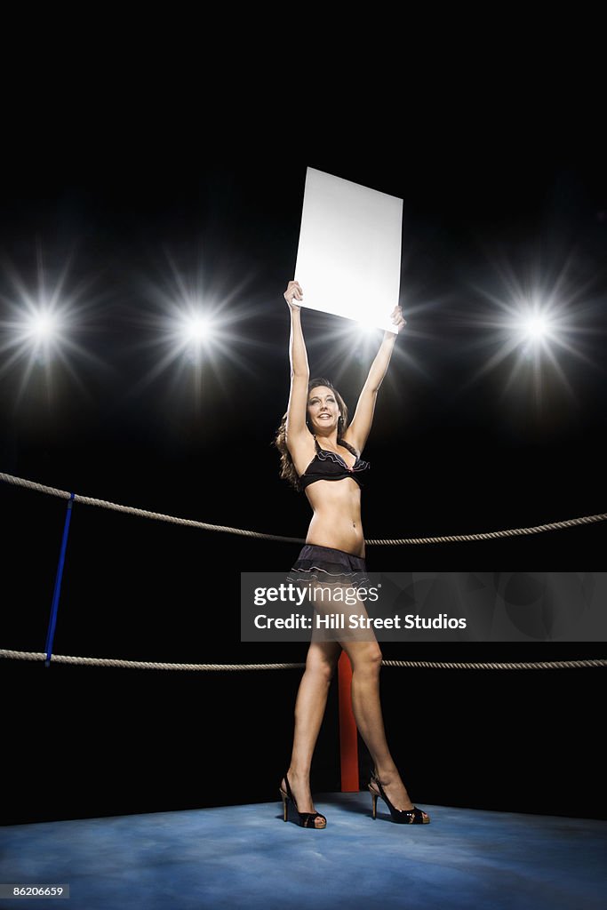 Ring girl holding sign in boxing ring