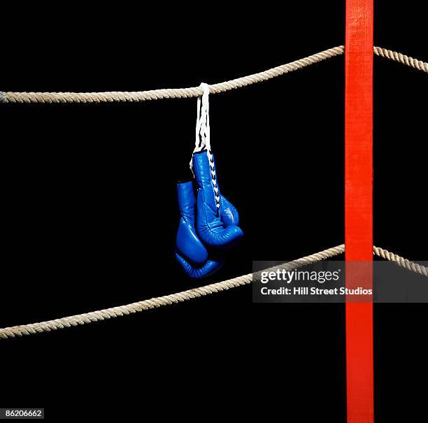 boxing gloves hanging from boxing ring - empty boxing ring foto e immagini stock