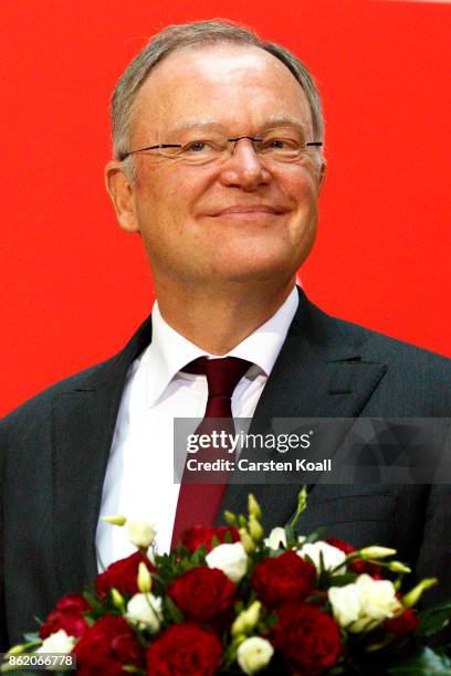 Stephan Weil, incumbent SPD candidate in yesterday's state elections in Lower Saxony, holds flowers at SPD headquarters on October 16, 2017 in...