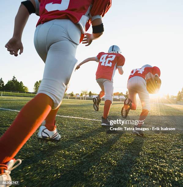 football players running on field - american football field low angle stock pictures, royalty-free photos & images