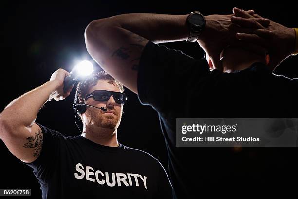 security guard shining flashlight on man - bouncer guarding stock pictures, royalty-free photos & images