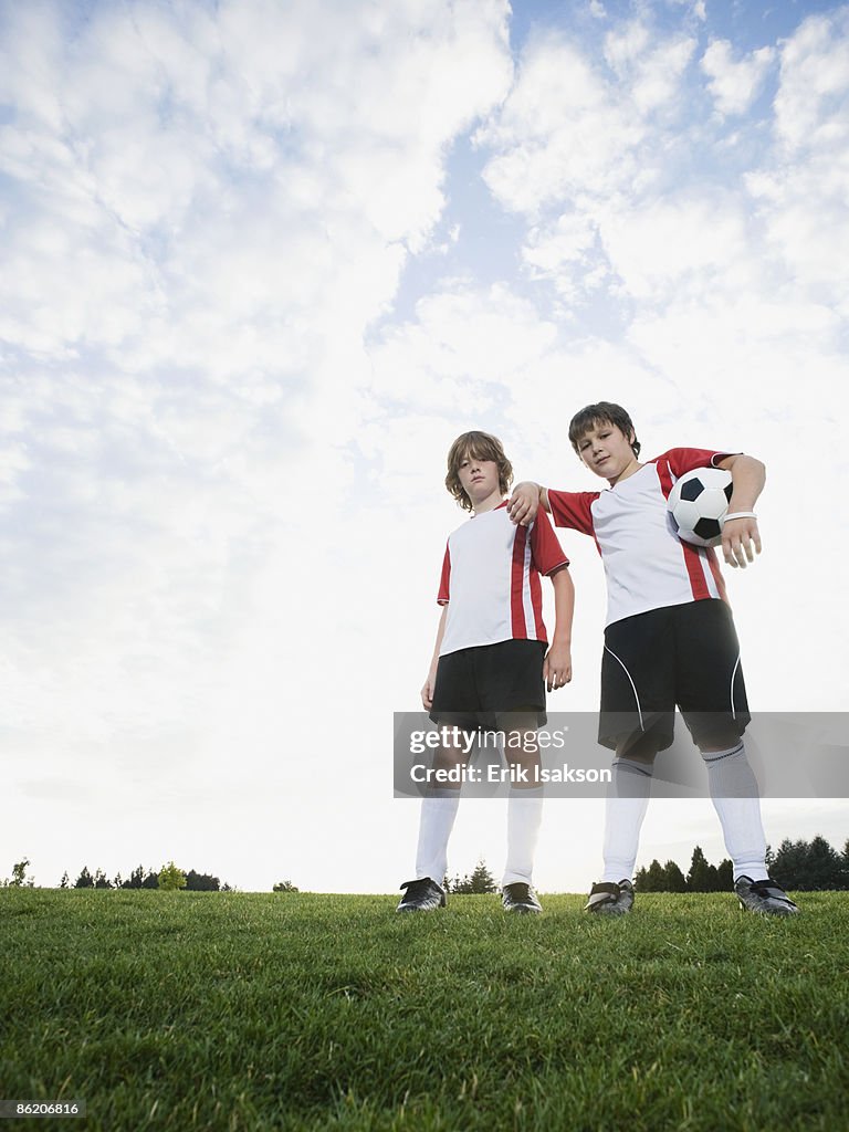 Portrait of boys in soccer uniforms holding ball