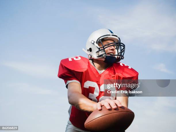 quarterback holding football - quarterback teenager stock pictures, royalty-free photos & images