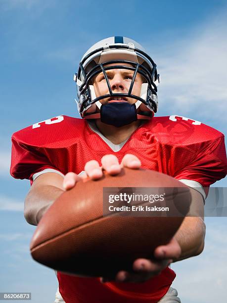 quarterback holding football - quarterback teenager stock pictures, royalty-free photos & images