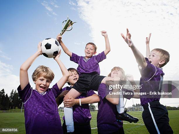 boys soccer team celebrating with trophy - child trophy stock-fotos und bilder