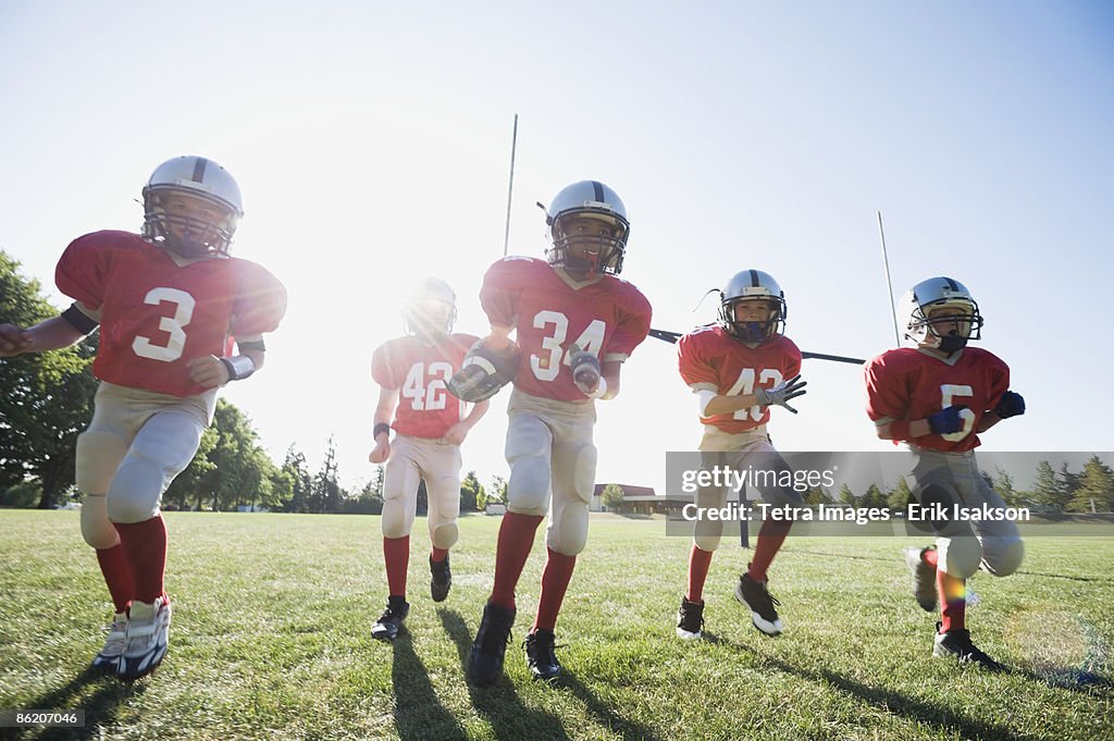 Football players running on field