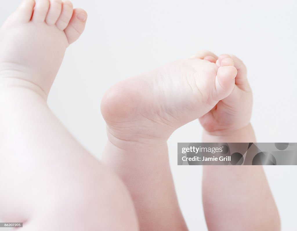 Close up of baby grabbing feet