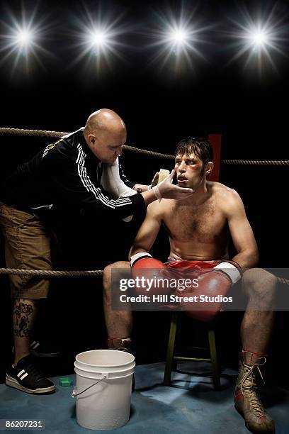 coach wiping boxer with sponge in corner of boxing ring - championship ring stockfoto's en -beelden