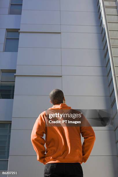 man looking up at highrise - man looking up photos et images de collection