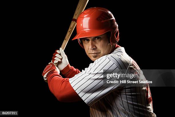 portrait of batter holding baseball bat - baseball helmet photos et images de collection